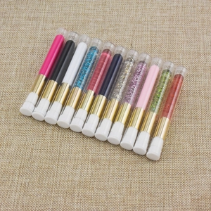 Detail view of various eyelash cleansing brushes in transparent tubes with glitter fillers