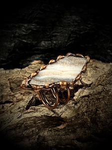 Détail macro d'une bague en agate solaire naturelle avec bordure en bronze faite main