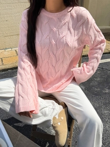 Detail of the pink cable knit texture on a long-sleeved crewneck sweater for women