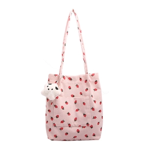Pink corduroy bucket bag with red strawberry print and a white plush toy charm