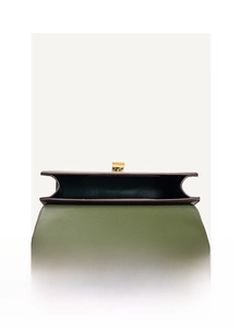 Detail view of olive green flap bag showing interior space and gold metal lock