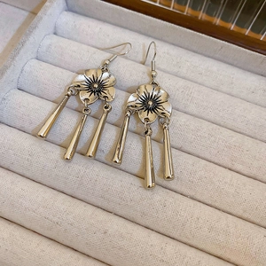 Detail shot of vintage silver flower tassel earrings on grey velvet jewelry organizer