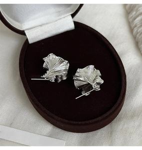 Macro detail of ginkgo leaf earrings with pearl in a premium velvet jewelry box