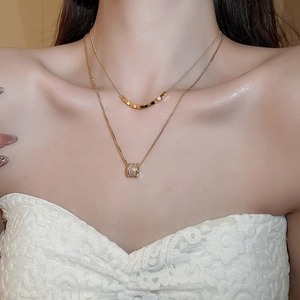 Detail of 18k gold plated double layer necklace with cubic zirconia cylinder pendant
