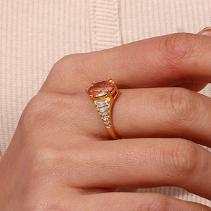 Close-up of 18K gold plated ring with orange oval zircon and small side diamonds