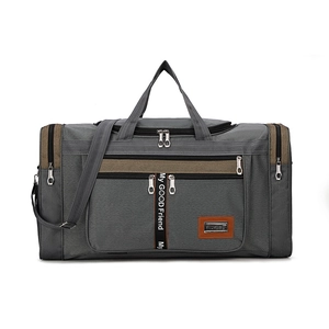 Detail of grey travel bag with brown straps featuring multiple zip pockets and handles