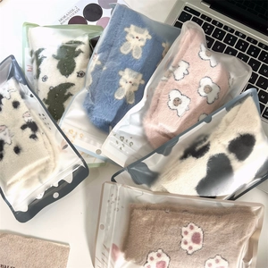 Detailed view of assorted coral fleece socks in premium frosted zipper packaging