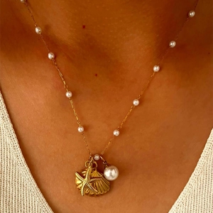 Golden starfish seashell and pearl charm necklace with delicate pearl accents on the chain