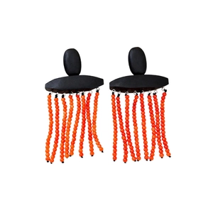Ethnic style earrings with black geometric studs and orange beaded tassels on white background