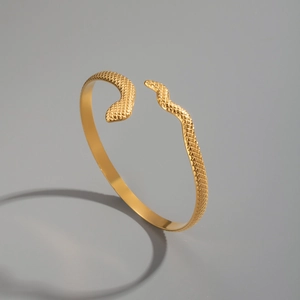 Detailed macro view of golden snake-shaped cuff bracelet with fine scale texture patterns