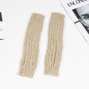 Close-up of beige cable knit arm warmers featuring classic textured patterns and ribbed cuffs