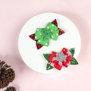 Detail of Christmas bow hair clips with glitter Christmas tree and snowflake on a white plate
