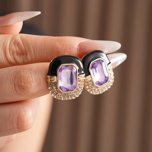 Macro shot of vintage black enamel square earrings with purple crystal and pave rhinestones