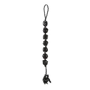 Detailed handmade black raw stone hanging ornament with woven mesh and pebble tassels
