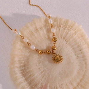 Macro detail of sun pendant necklace with freshwater pearls on coral stand
