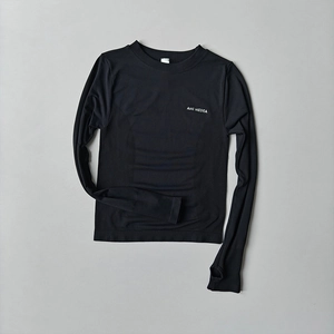 Close-up of black compression yoga top featuring thumb holes and breathable fabric texture