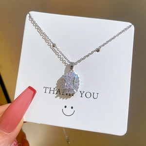 Detailed macro view of silver titanium steel necklace with a sparkling zircon pendant