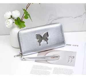 Detail of silver long wallet with butterfly metal piece and detachable wrist strap