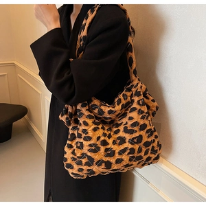 Detailed view of leopard print quilted tote bag worn on shoulder over black coat