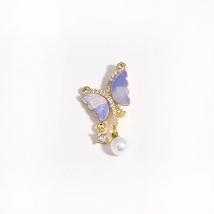 Detailed view of a purple gradient butterfly pendant with zircons and a white pearl drop