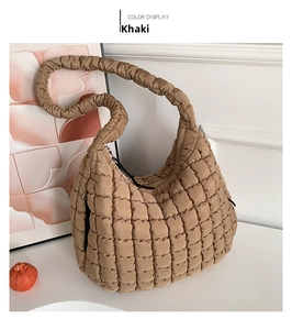 Detail view of khaki quilted puffer shoulder bag with ruched handle and soft texture