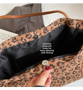 Close-up of leopard print tote bag featuring a magnetic snap closure and leather straps