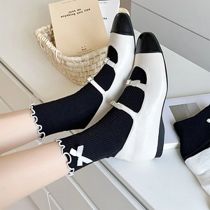 Detail of black JK socks with white ruffle lace trim and bow knot detail on Mary Jane shoes