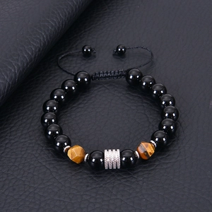 Detail of 10mm black magnetic beads with engraved silver cylinder on leather background