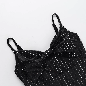 Detail of black velvet dress featuring silver sequin dots and a large front bow design