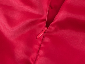 Détail d'une robe en satin rouge montrant une fermeture éclair invisible de haute qualité