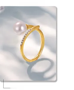 Close-up of elegant gold pearl open ring featuring pavé cubic zirconia setting