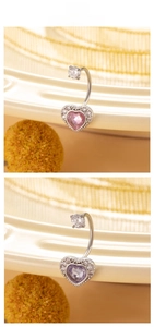 Detailed view of heart-shaped belly rings with pink and purple zircons on steel rods