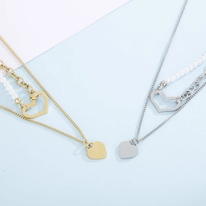 Double-layered stainless steel heart necklace with pearls shown on a two-tone background
