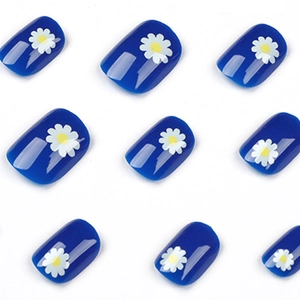 Navy blue press-on toenails featuring white daisy patterns on a white background