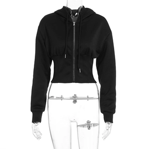Detail of black cropped hoodie featuring cinched waist design and silver metal zipper