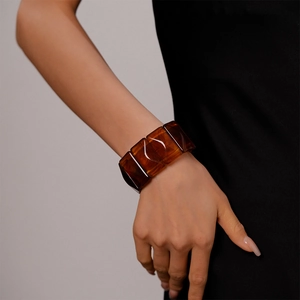 Detail view of the amber resin rectangular block bracelet on a model's wrist