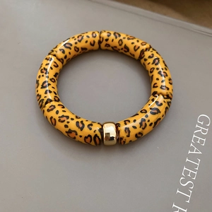 Detailed view of leopard print bamboo style bracelet with polished golden metal bead