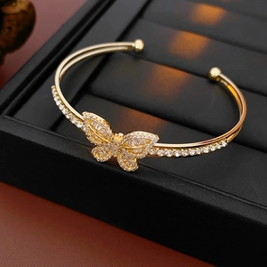 Detail of gold butterfly open cuff bracelet with sparkling zircon stones in black jewelry box