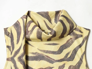 Close-up of elegant zebra print sleeveless dress featuring high neckline in yellow and black