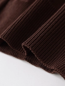 Detailed macro view of dark coffee ribbed knit fabric texture and premium craftsmanship