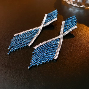 Detail von geometrischen Quastenohrringen mit dunkelblauen Zirkonia und rechteckigen Diamanten