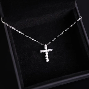 Macro shot of silver zircon cross pendant necklace in a luxury black velvet jewelry box