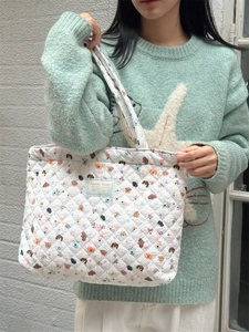 Quilted tote bag detail featuring colorful cartoon dog prints and soft padded texture