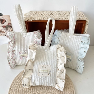 Detailed view of quilted cotton handbags featuring floral ruffles and snap button closure