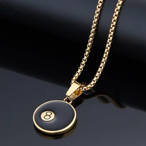 Close-up of golden lucky number 8 billiard ball pendant with reflective black base