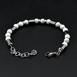 Détail du bracelet perlé montrant le logo S.STEEL gravé et le fermoir mousqueton en acier
