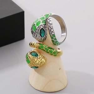 Snake rings in silver and gold steel with green crystal eyes and green enamel scales