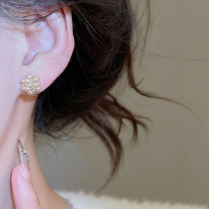 Close-up of pearl flower stud earrings with diamonds on model for an elegant look