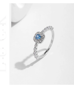 Macro detail of s925 silver ring featuring a square blue stone and micro-pave crystals