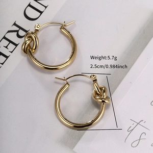 Detailed view of 2.5cm gold knot hoop earrings featuring a polished twisted metal design